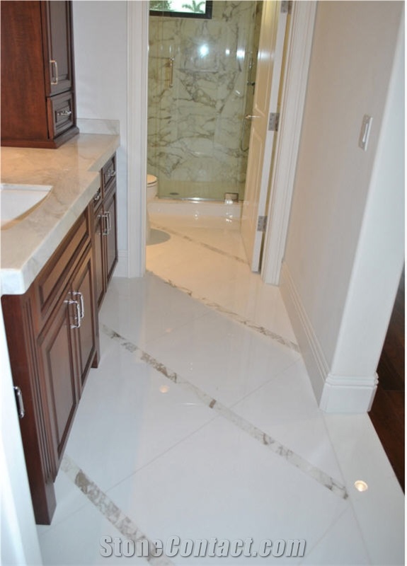 Traditional Bathroom Featuring White Marble Vanity and Calacatta Gold Marble Tile Wall